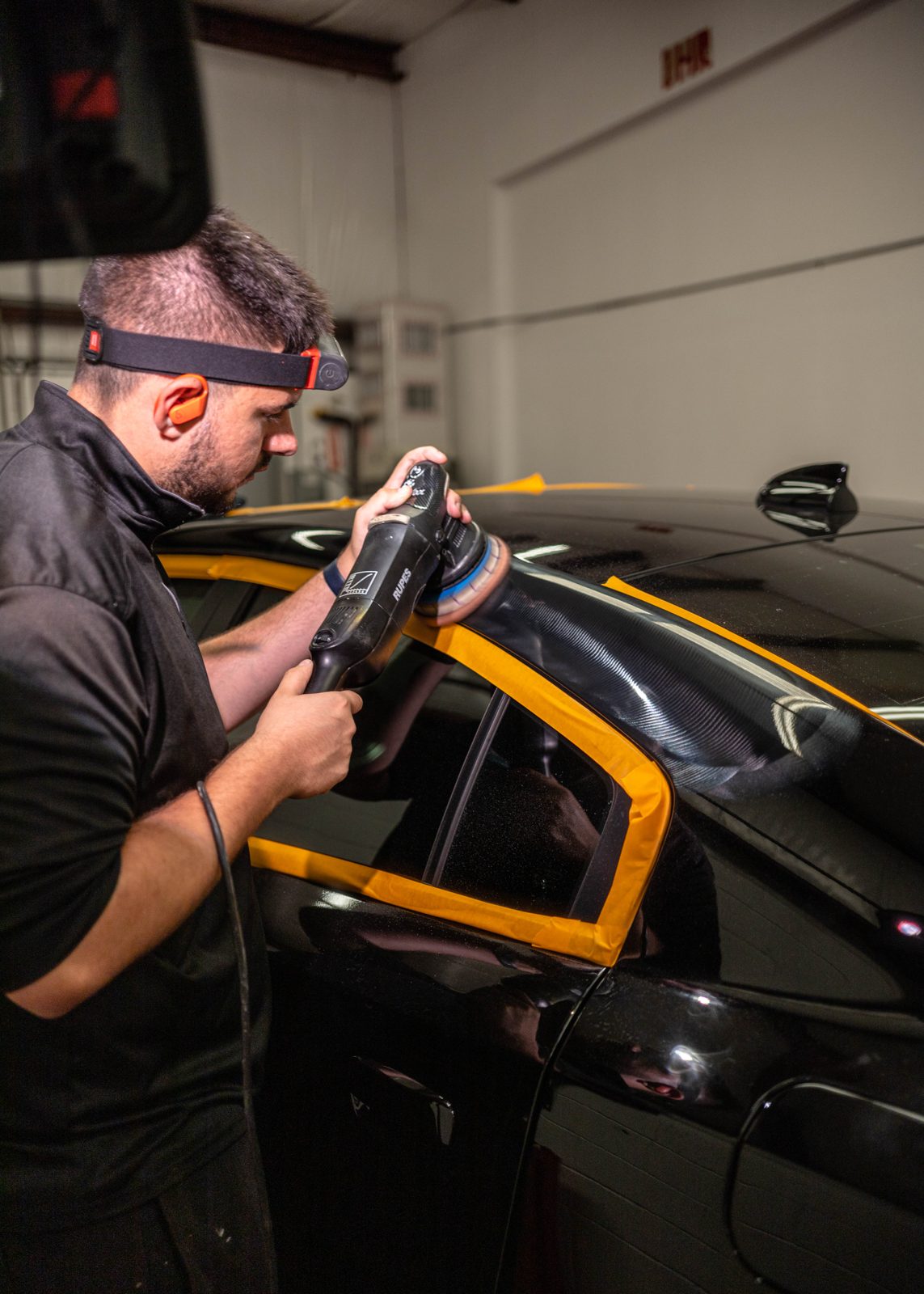 Obsidian detailer applying paint protection film to a Cockeysville client's car