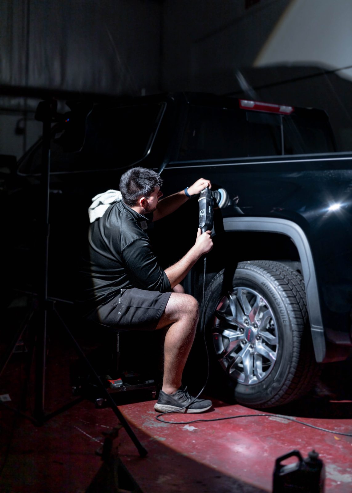 Detailer buffing a black truck during paint correction in Cockeysville
