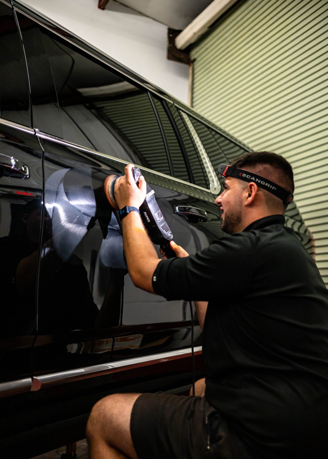 Obsidian detailer working on a black car window in Baltimore
