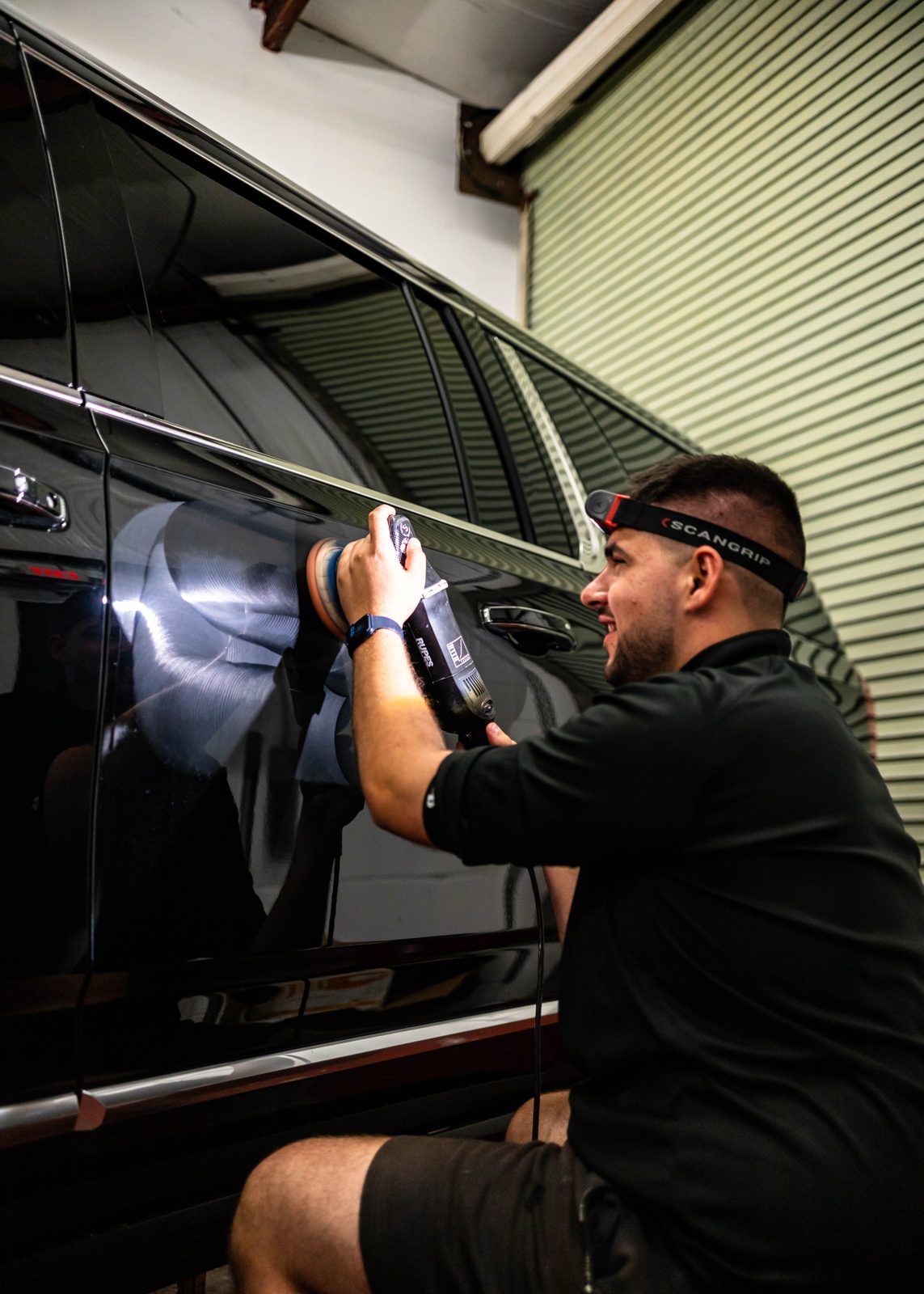 Obsidian detailer cleaning a black car interior at a Baltimore driveway