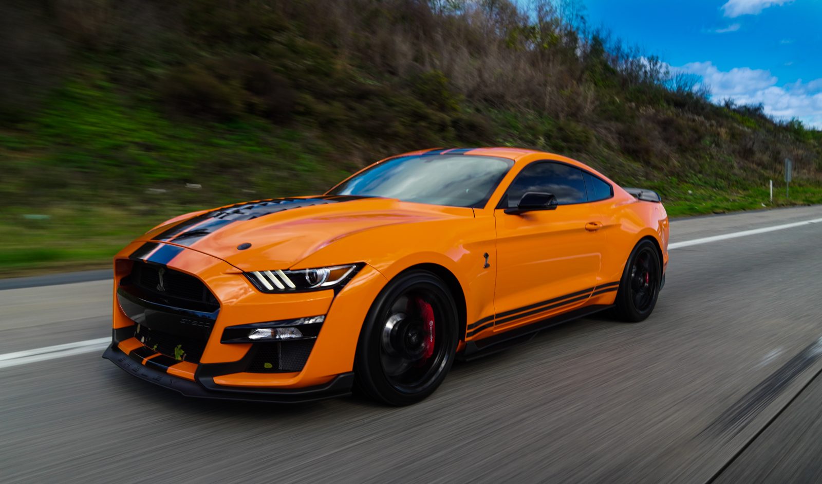 Orange Shelby GT500 on the road, detailed on a recurring family maintenance plan in Baltimore